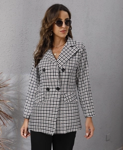 Detail of classic houndstooth blazer featuring double-breasted buttons and notched lapels