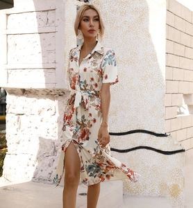 Detailed close-up of a floral summer shirt dress with a button-up front and high side slit