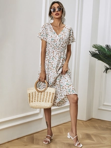 Detail of the white floral dress featuring a V-neckline and elastic waist design