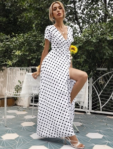 Detail eines weißen Polka-Dot-Kleides mit tiefem V-Ausschnitt und hohem Beinschlitz