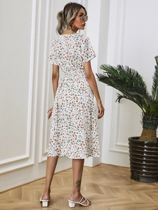 Detail of floral summer dress showing elastic waist design and small yellow flower print