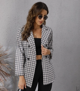 Detail of classic black and white houndstooth blazer with double-breasted buttons