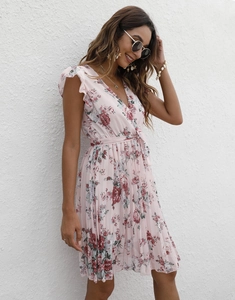 Détail d'une robe portefeuille rose à fleurs col V avec manches à volants et lien à nouer