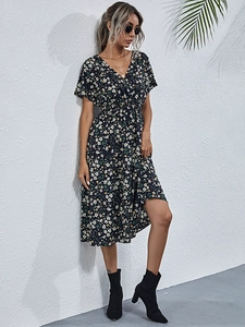Detail of V-neck floral summer dress with small white and yellow prints on dark fabric