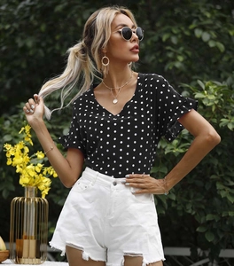 Detailansicht von Polka-Dot-Oberteil mit Rüschenärmeln und weißer Destroyed-Jeansshorts