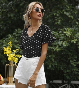 Detailaufnahme der Polka-Dot-Bluse mit V-Ausschnitt, Rüschenärmeln und Sommer-Styling