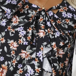 Dettaglio camicetta floreale in chiffon con scollo a V, fiocco e colletto con volant