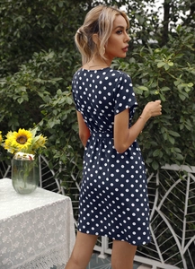 Détail d'une robe d'été bleu marine à pois montrant la coupe ajustée du dos et de la taille