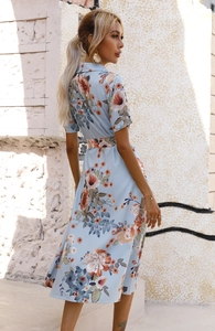 Close-up of a blue floral midi dress with shirt collar and waist belt in natural outdoor light