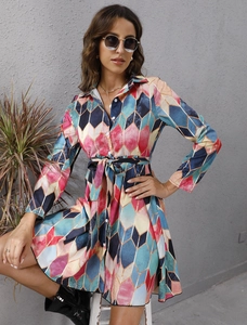 Detail view of colorful geometric print shirt dress with button-up front and waist tie
