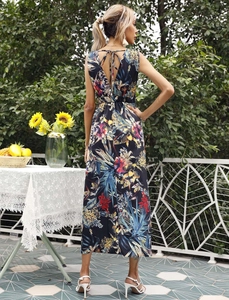 Detail of tropical floral maxi dress featuring a deep V-back with an elegant bow tie design