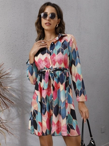 Detail of geometric print shirt dress with button-up front and adjustable waist tie