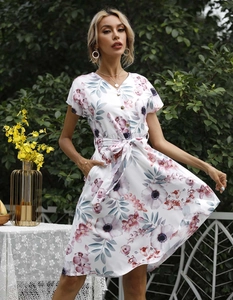 Detail eines sommerlichen Blumenkleids mit V-Ausschnitt, Knopfleiste und Bindegürtel