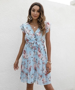Détails de la robe fleurie bleu clair avec col en V, nouée à la taille et ourlet plissé