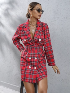 Detail of red tartan blazer dress featuring double-breasted white buttons and waist belt