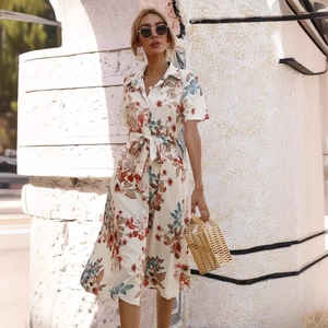 Floral short sleeve shirt dress with button-down front and waist tie in outdoor setting