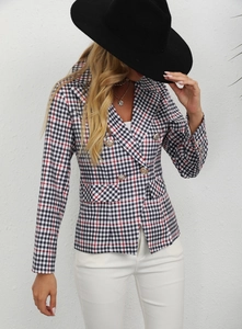 Detail of plaid blazer featuring double-breasted gold buttons and tailored pockets