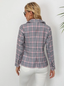 Detail of plaid blazer sleeve with metallic buttons and classic tailored back seams