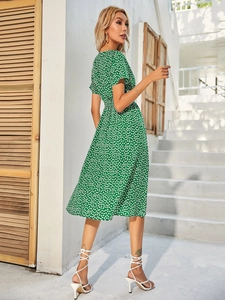 Side view of a green floral summer midi dress with short sleeves and a flowy A-line hem