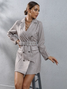 Detail of houndstooth blazer dress featuring double-breasted buttons and matching waist belt