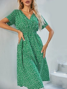 Detail of smocked waist and dainty white floral print on green V-neck short sleeve dress