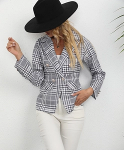 Detail of classic black and white plaid blazer with gold buttons and peak lapel design