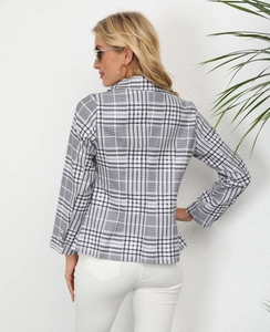 Detailed view of plaid blazer sleeve featuring elegant gold decorative buttons
