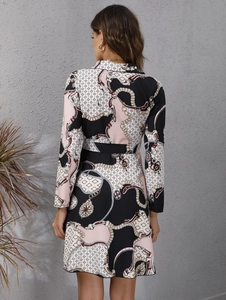 Detail view of the elegant geometric chain print and fabric texture on a long sleeve dress