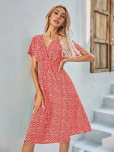 Detail of red floral dress featuring a deep V-neck and elastic high waist design