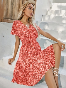 Detail of red floral summer dress with white daisy print and elegant V-neck design