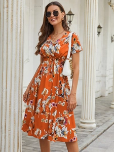 Close-up of orange floral midi dress with deep V-neck and high elastic waist details