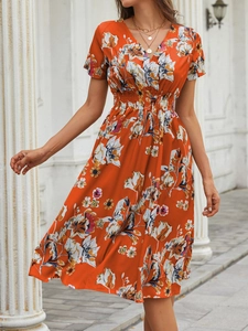 Detailed view of V-neckline and high waist floral pattern on orange summer dress