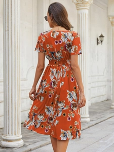 Detailed back view of an orange floral short-sleeved dress with elastic waist