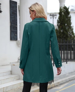 Detail of dark green blazer featuring metal cuff buttons and delicate black lace trim
