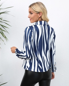 Detail of zebra print blazer sleeve featuring three decorative gold buttons on the cuff