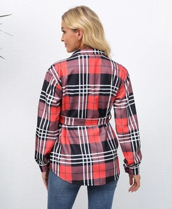 Detail of red and black plaid jacket with waist tie and slim fit silhouette on model