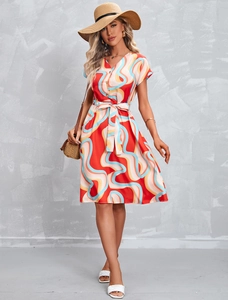 Close-up of elegant V-neckline and colorful abstract print on summer dress with buttons