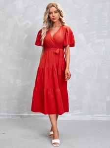 Detail of red V-neck dress with ruffled sleeves and multi-layer tiered cake skirt