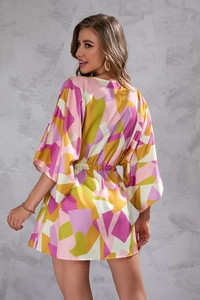 Detail of colorful geometric print mini dress featuring batwing sleeves and elastic waist
