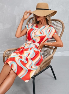 Close-up of V-neck summer dress with colorful wave patterns and waist tie detail