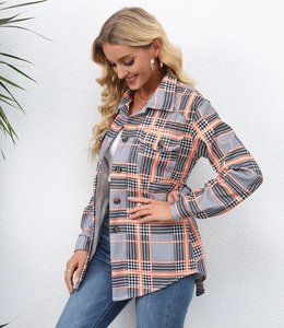 Close-up of women's orange and black plaid shacket with buttons and chest pockets