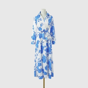 Détail d'une robe maxi imprimé floral bleu avec jupe plissée et nœud à la taille