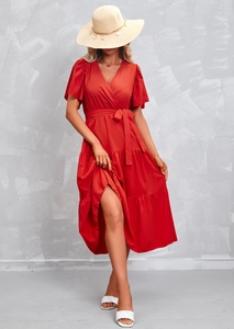 Detail of red V-neck wrap dress with ruffle sleeves and waist tie in a summer style