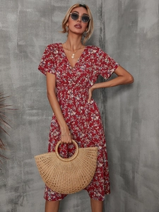Detail of V-neck floral summer dress in deep red with short sleeves and waist tie