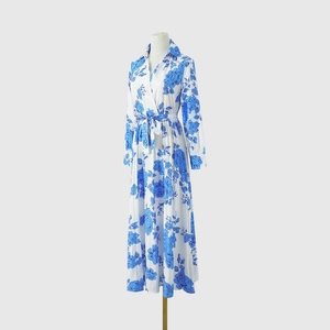 Détail de robe à manches longues, motif floral bleu, col chemise et lien à nouer