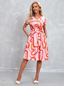 Close-up of V-neck floral midi dress featuring button front and adjustable waist tie
