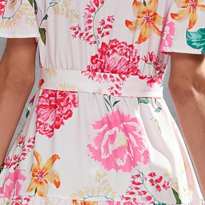 Detail of floral print summer dress showing the high waist tie belt and ruffles