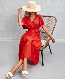 Detail of orange V-neck wrap dress featuring tiered skirt and ruffled short sleeves