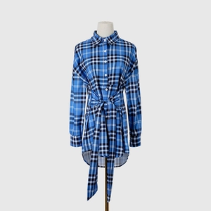 Detalle de vestido de cuadros azules de manga larga con lazo y cuello de botones