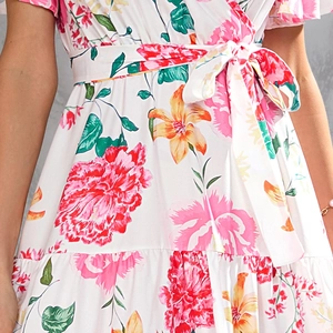 Detailed view of summer dress featuring vibrant floral print and waist-tie bow detail